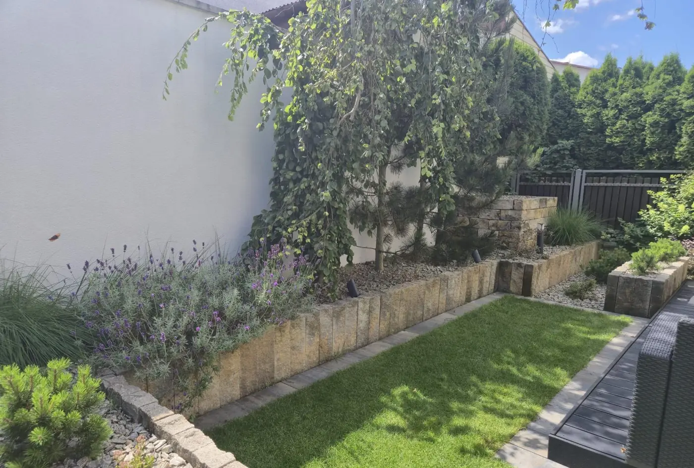 Wąski ogród przy domu – podwyższone rabaty z palisad i równy trawnik