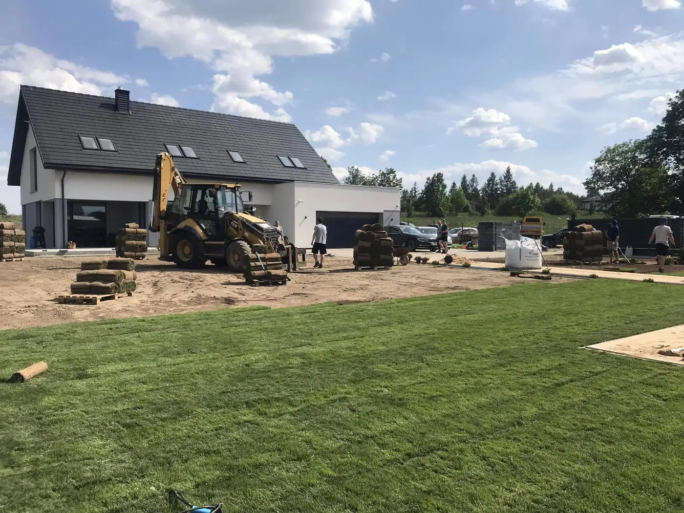 Układanie trawy z rolki przy nowym domu – nasza koparko-ładowarka
