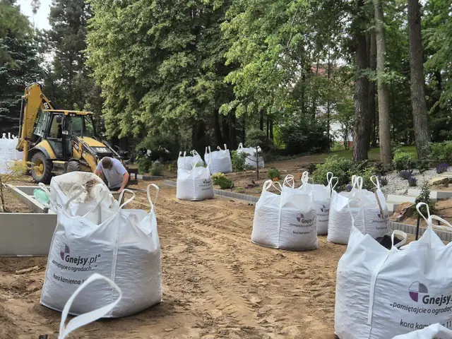 Kamień w workach i minikoparka na placu budowy ogrodu